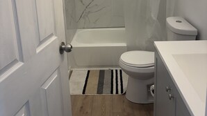 Un baño con bañera, inodoro y cortina de ducha.