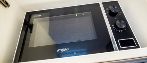 A microwave with a digital display, control knobs, and a brand name 'Whirlpool'.