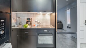 Eine moderne Küche mit Edelstahlgeräten, einem Backofen und einer Kaffeemaschine.