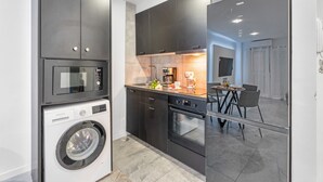 Eine moderne Küche mit Waschmaschine, Backofen und Mikrowelle.