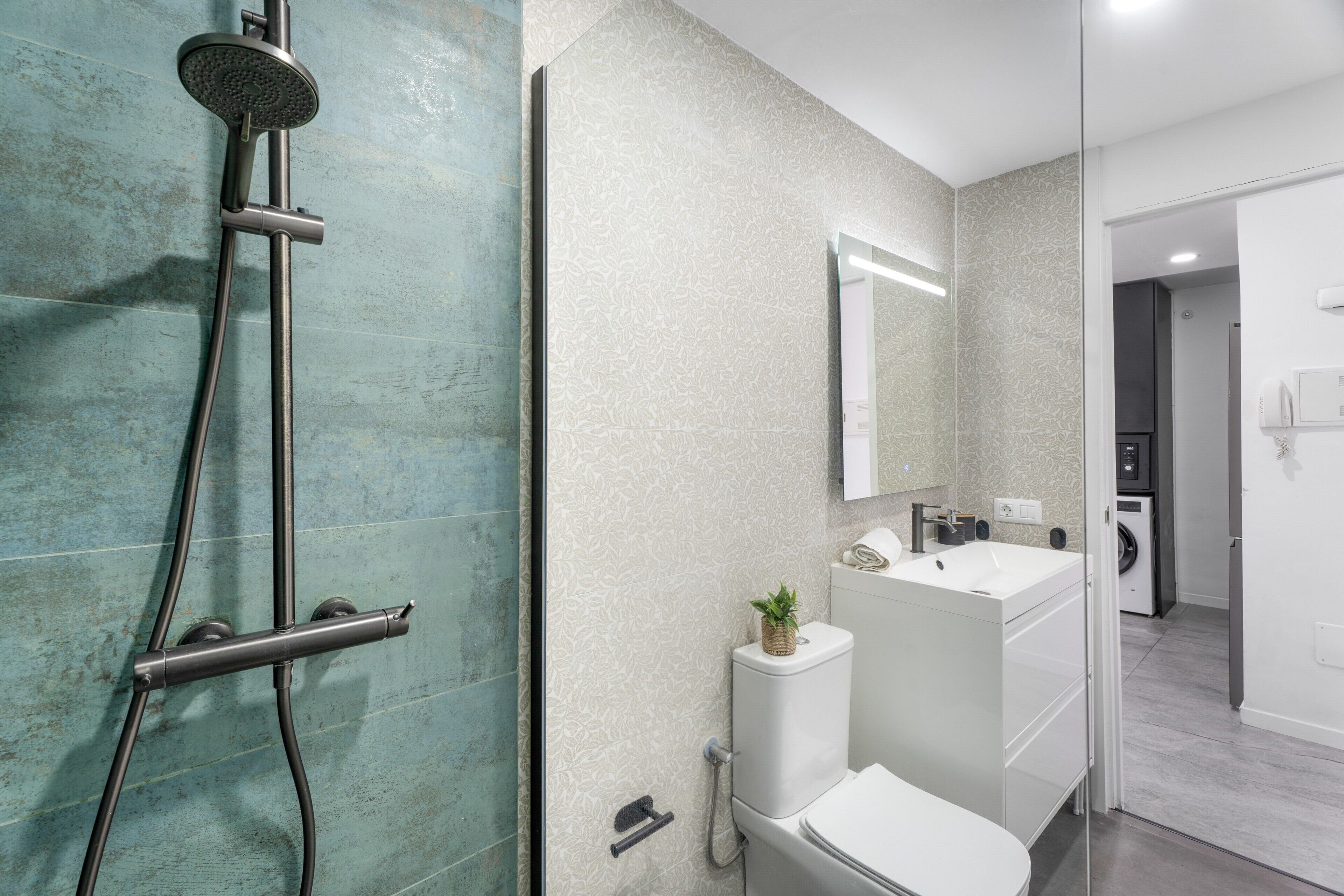Une salle de bain moderne équipée d’une douche, de toilettes et d’un lavabo.
