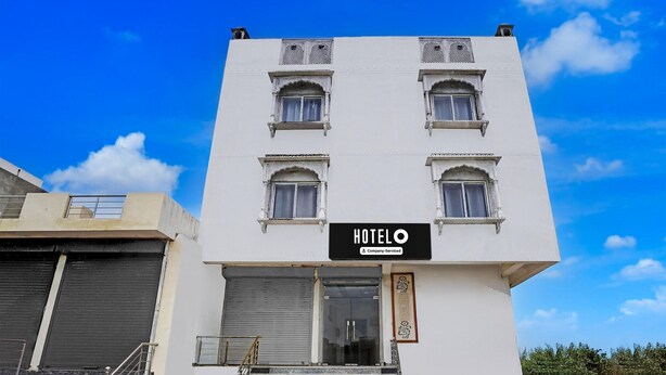 A white building with a sign reading 'HOTEL' and a staircase leading to the entrance. - NON AC Saver Hotel O Mehta College (Amer)