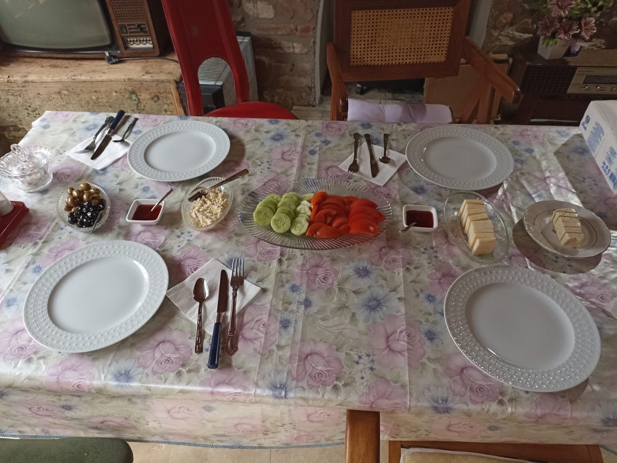 A table set for a meal with plates, cutlery, and various food items.