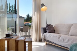 Un salon moderne avec un canapé, une table avec une télécommande et une lampe.