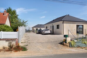 A residential area with two houses, a gravel driveway, and parked cars. - Holiday Home 'Maison Sci Entre Foret Et Mer' with Wi-Fi (Millebosc)