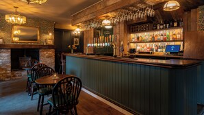 A bar area with wooden furniture, a bar counter, and a computer monitor.