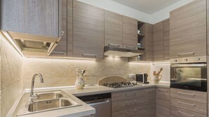 A modern kitchen with a built-in dishwasher, stainless steel sink, and a gas stove. - Beautiful private villa for 4 people with WIFI, A/C and TV (Massa)