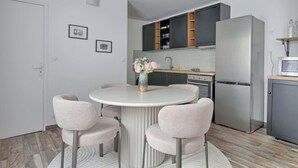 Eine moderne Küche mit Kochinsel, eingebauten Schränken und einem Kühlschrank.