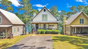 A two-story house with a porch, a welcome sign, and a gravel driveway. - New! No Worries on Lake Martin 3BR/3BA that sleeps 10, pets OK! (Dadeville)