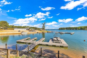 A calm lake with docks, a boat, and a clear sky. - New! No Worries on Lake Martin 3BR/3BA that sleeps 10, pets OK! (Dadeville)