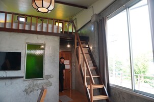 Una escalera conduce a una zona superior con vistas al exterior.