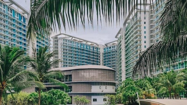 Un resort con piscina, palmeras y edificios modernos.