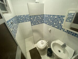 A bathroom with a toilet, bidet, and sink.