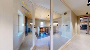 Una cocina moderna con armarios de madera, una zona de bar y un separador de vidrio.