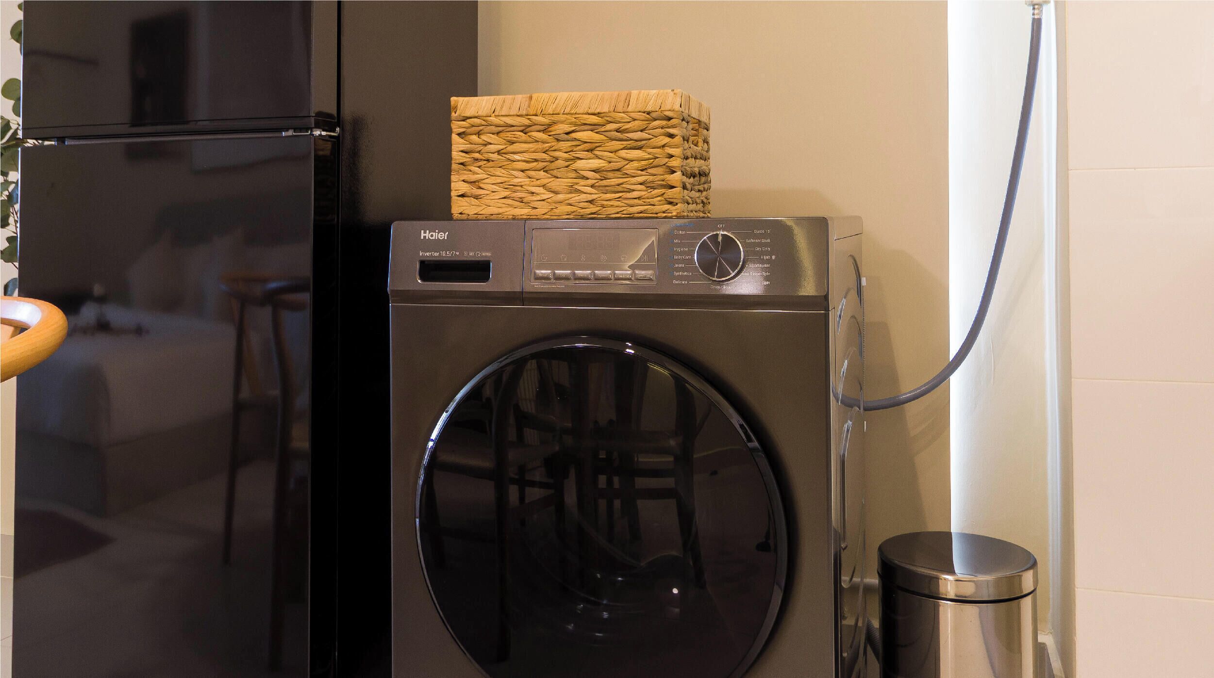 A compact washer and dryer unit with a control panel and a basket on top.
