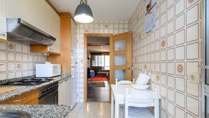 A kitchen with a stove, microwave, and granite countertop. - Vacation Apartment in O Grove with Wi-Fi and Air Conditioning (O Grove)