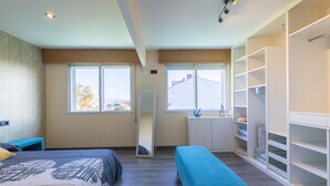 A bedroom with a bed, a bench, a wardrobe, and a window with a view. - Vacation Apartment in O Grove with Wi-Fi and Air Conditioning (O Grove)
