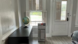 Ein Zimmer mit Schreibtisch, Globus, Heizkörper und einer Tür mit Fenster.