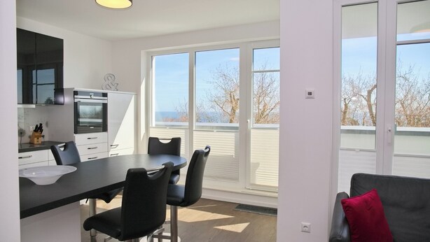 Una cocina moderna con comedor, ventanas amplias y vistas al exterior.