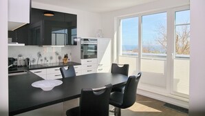 Una cocina moderna con comedor, ventanas amplias y vistas al exterior.