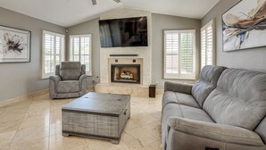 A living room with a fireplace, a ceiling fan, a sofa, a recliner, and a coffee table. - Game Room, Backyard Oasis! Glendale Group Getaway (Glendale)