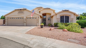 A two-story house with a garage, a front entrance, and a small garden area with rocks and plants. - Game Room, Backyard Oasis! Glendale Group Getaway (Glendale)