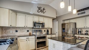 A kitchen with white cabinetry, a granite countertop, stainless steel appliances, and a sign that says 'Eat.' - Game Room, Backyard Oasis! Glendale Group Getaway (Glendale)