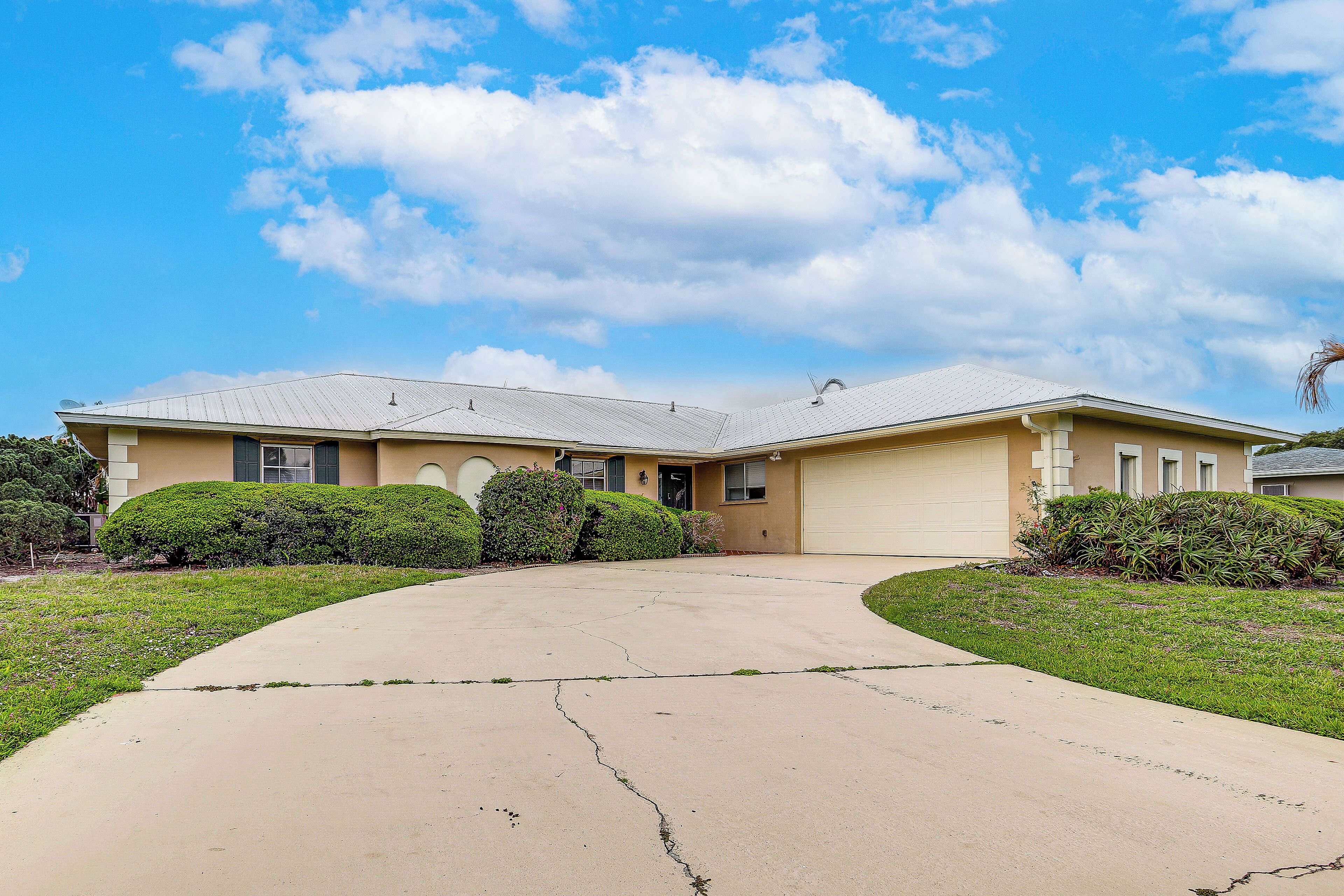 A residential house with a driveway, garage, and well-maintained lawn.
