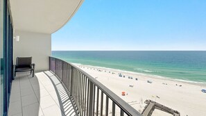 A balcony with a view of a beach, a chair, and a railing. - Beachfront 3BR at Phoenix IX!  New to the Rental Market! (Orange Beach)