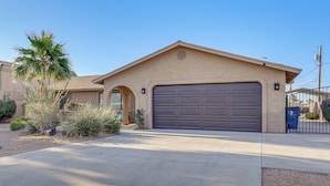 A residential house with a garage, a driveway, and landscaping. - Quiet Home w/ Spacious Yard in Lake Havasu City (Lake Havasu City)