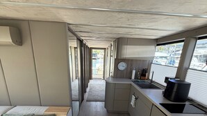 Un espacio interior funcional con kitchenette, zona de estar y vistas por una ventana.