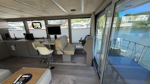 Un interior moderno con zona de cocina, asientos y vistas al agua.