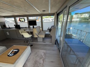 A modern interior with a kitchen area, seating, and a view of the water.