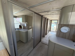 A modern interior with a kitchenette, a clock, and a view of the outside.