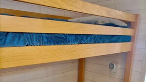 Una cama litera con colchón azul y estructura de madera.