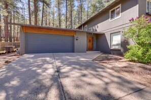 A two-story house with a garage, a front door, and a small porch area. - Bring Your Pets! Family Flagstaff Haven w/ Yard (Flagstaff)