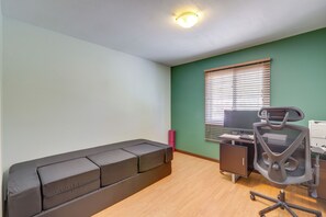 A room with a sectional sofa, a desk with a chair, a window with blinds, and a ceiling light. - Bring Your Pets! Family Flagstaff Haven w/ Yard (Flagstaff)