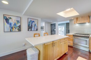 A modern kitchen with wooden cabinets, a white countertop, and a stainless steel stove. - Bring Your Pets! Family Flagstaff Haven w/ Yard (Flagstaff)