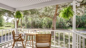 A wooden deck with two chairs and a table, surrounded by white railings and trees. - 2 Mi to Historic Dtwn St Augustine! Family Retreat (St. Augustine)