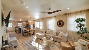 A spacious living area with a sofa, coffee table, and dining table.