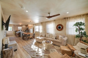 A spacious living area with a sofa, coffee table, and dining table.