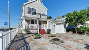 A two-story house with a front porch, a garage, and a small garden area.