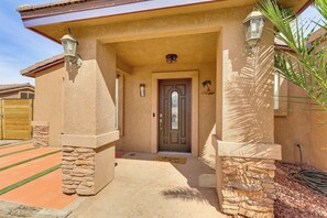 A house with a stone facade, a wooden door, and a welcome mat. - Outdoor Entertainment Area! Lake Havasu City Home (Lake Havasu City)