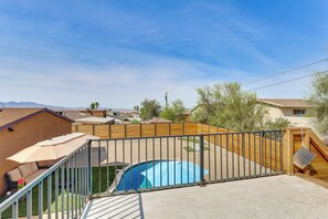 Ein Garten mit Schwimmbad, Holzzaun und Terrasse mit Gartenmöbeln.