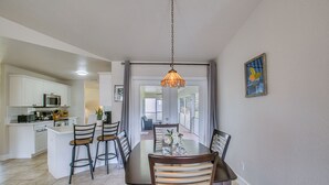 Uma área de refeições com mesa, cadeiras e um lustre.