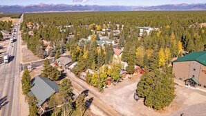 Oversigtsbillede af et boligområde med huse, en vej og et bjerglandskab i baggrunden.