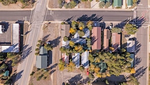 Oversigtsbillede af et boligområde med flere huse, en hovedvej og en parkeringsplads.