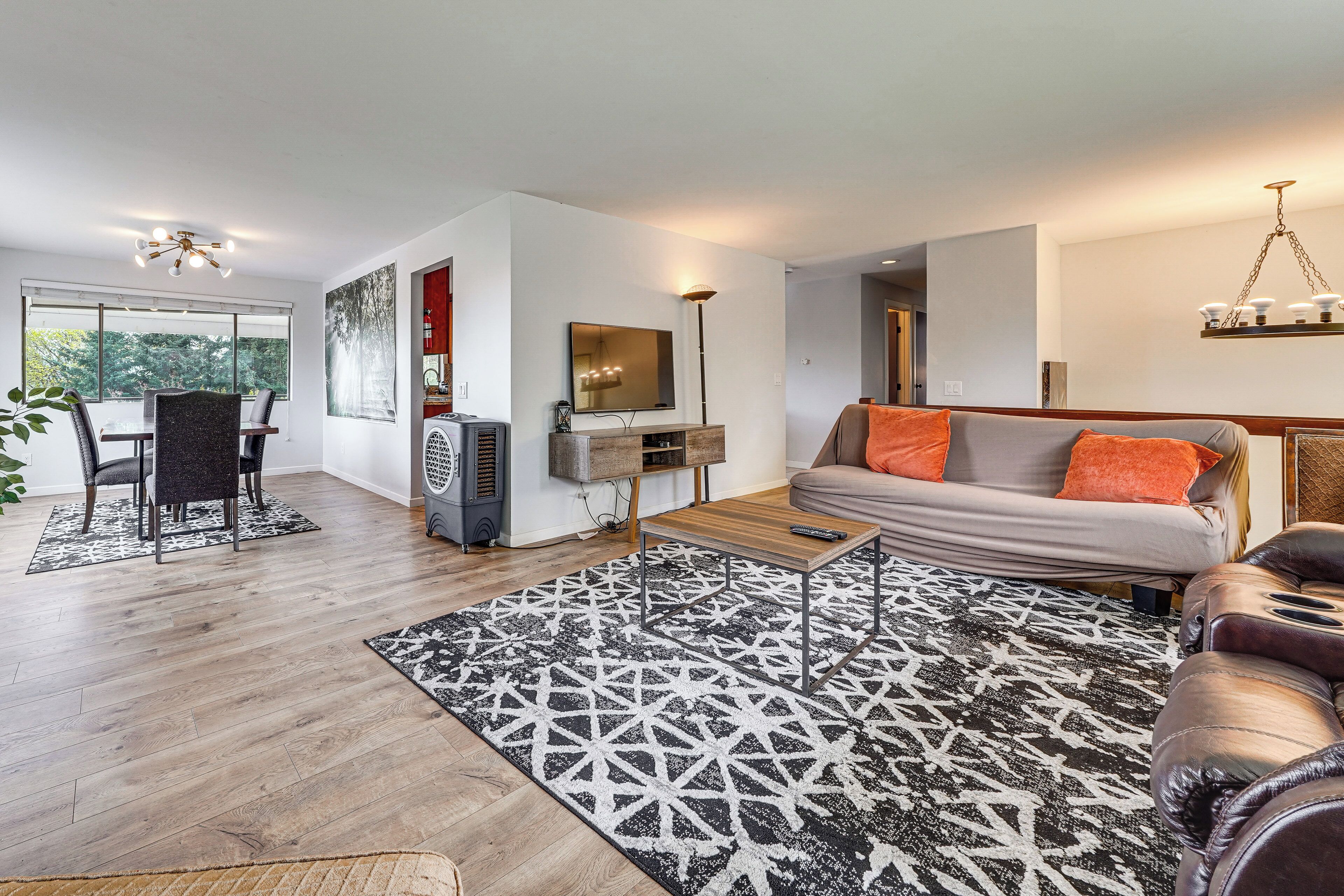 Uma sala de estar moderna com sofá, mesa de centro e área de jantar.