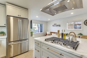 A modern kitchen with stainless steel appliances, a gas stove, and a large island. - Shop, Dine, Walk to Ocean! San Clemente Retreat (San Clemente)