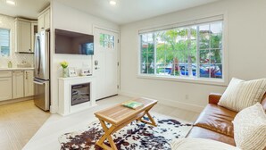 A modern kitchen with a refrigerator, oven, and window.